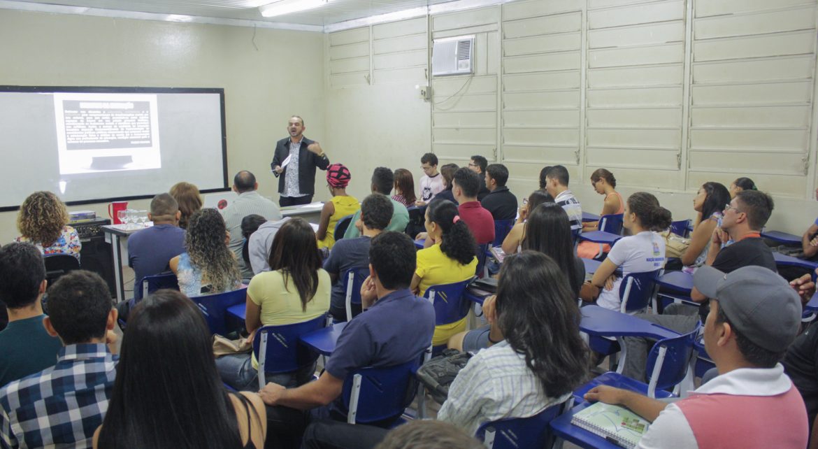 Um professor em sala de aula fala com os alunos.