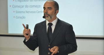 O professor Allan Kardec Duailibe Barros Filho aparece em frente a um quadro branco ministrando aula.