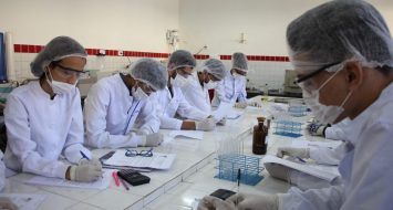 Estudantes em laboratório da UEMASUL realizam procedimentos científicos.