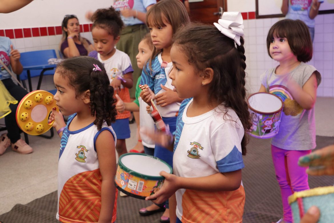 Seis crianças seguram alguns brinquedos dentro da sala de aula, durante a Semana Mundial do Brincar na UEMASUL.