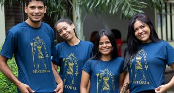 Acadêmicos do curso de História exibem posam para foto com as camisetas do curso.