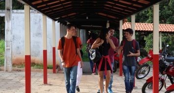 Acadêmicos conversando enquanto caminham em um corredor da UEMASUL.