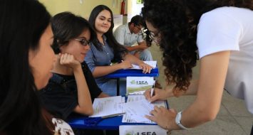 Participantes do evento e uma pessoa da comissão confirmando a presença dos mesmos via assinatura.