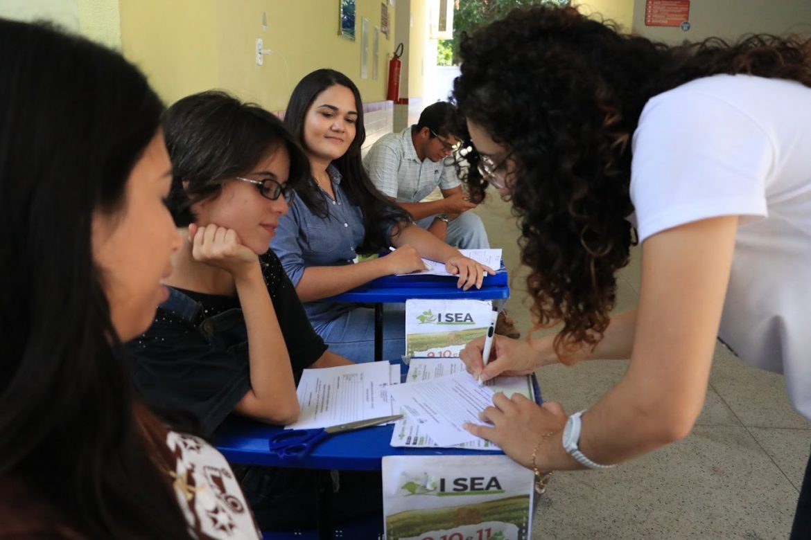 Participantes do evento e uma pessoa da comissão confirmando a presença dos mesmos via assinatura.