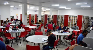 Cerca de 10 alunos estão sentados nas messas estudando na biblioteca da UEMASUL.